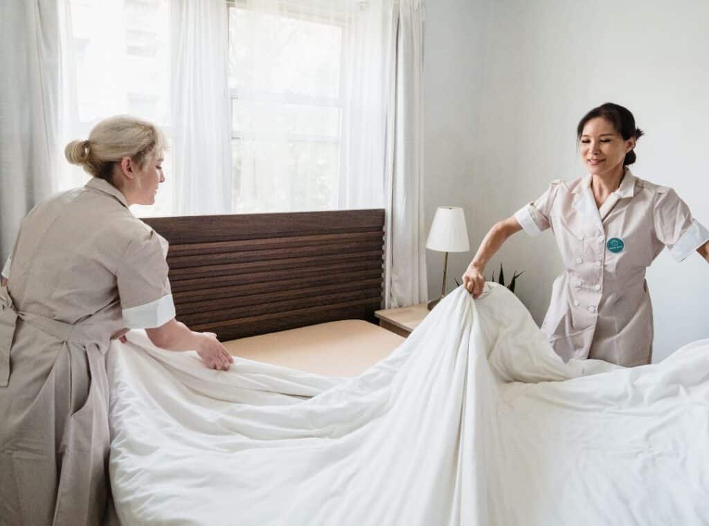 Two cleaning lady changing the mattress